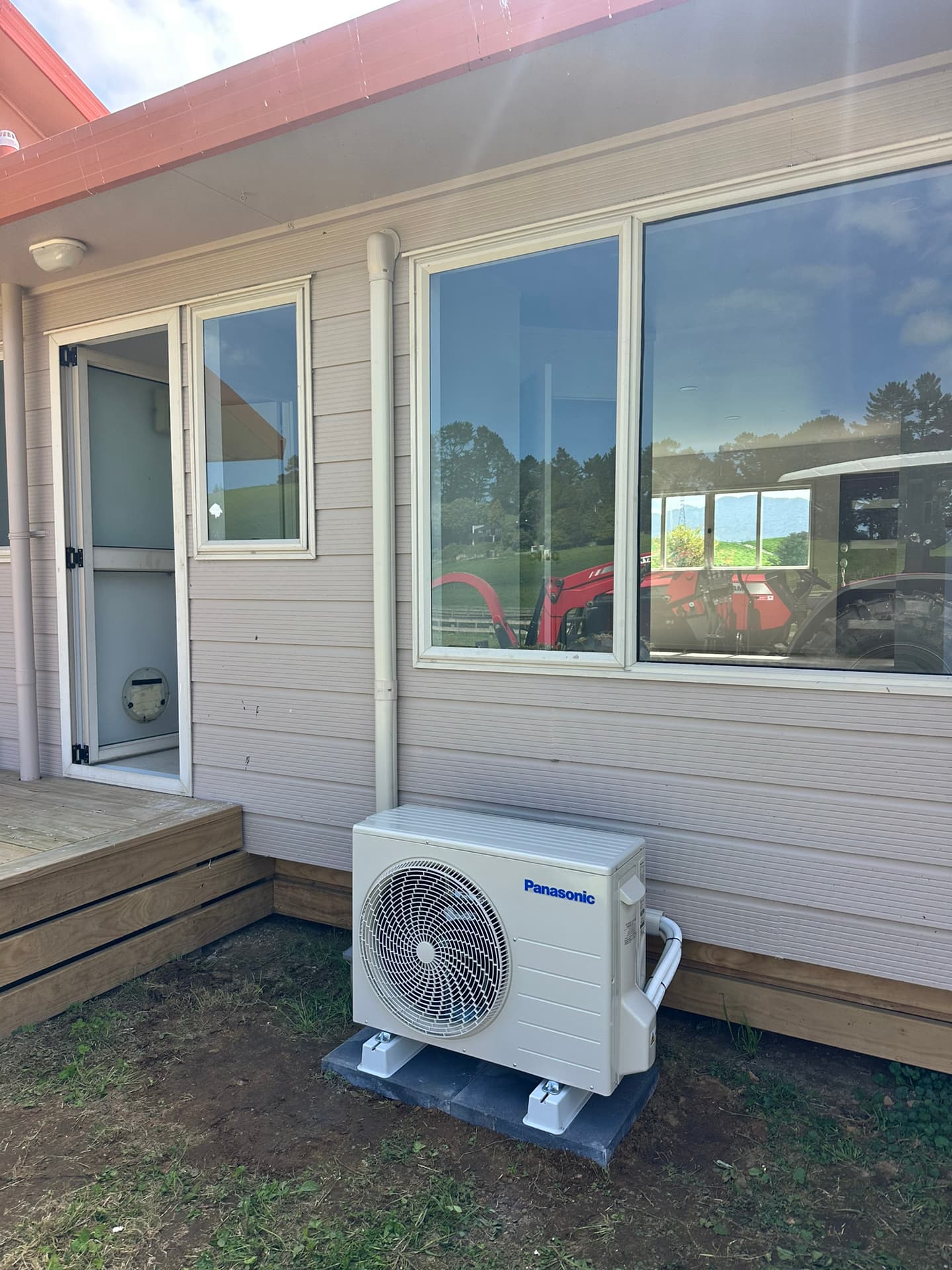 Outdoor heat pump unit professionally installed beside a residential home by Climate Systems 2017 Ltd, Waikato heating and air conditioning specialists.