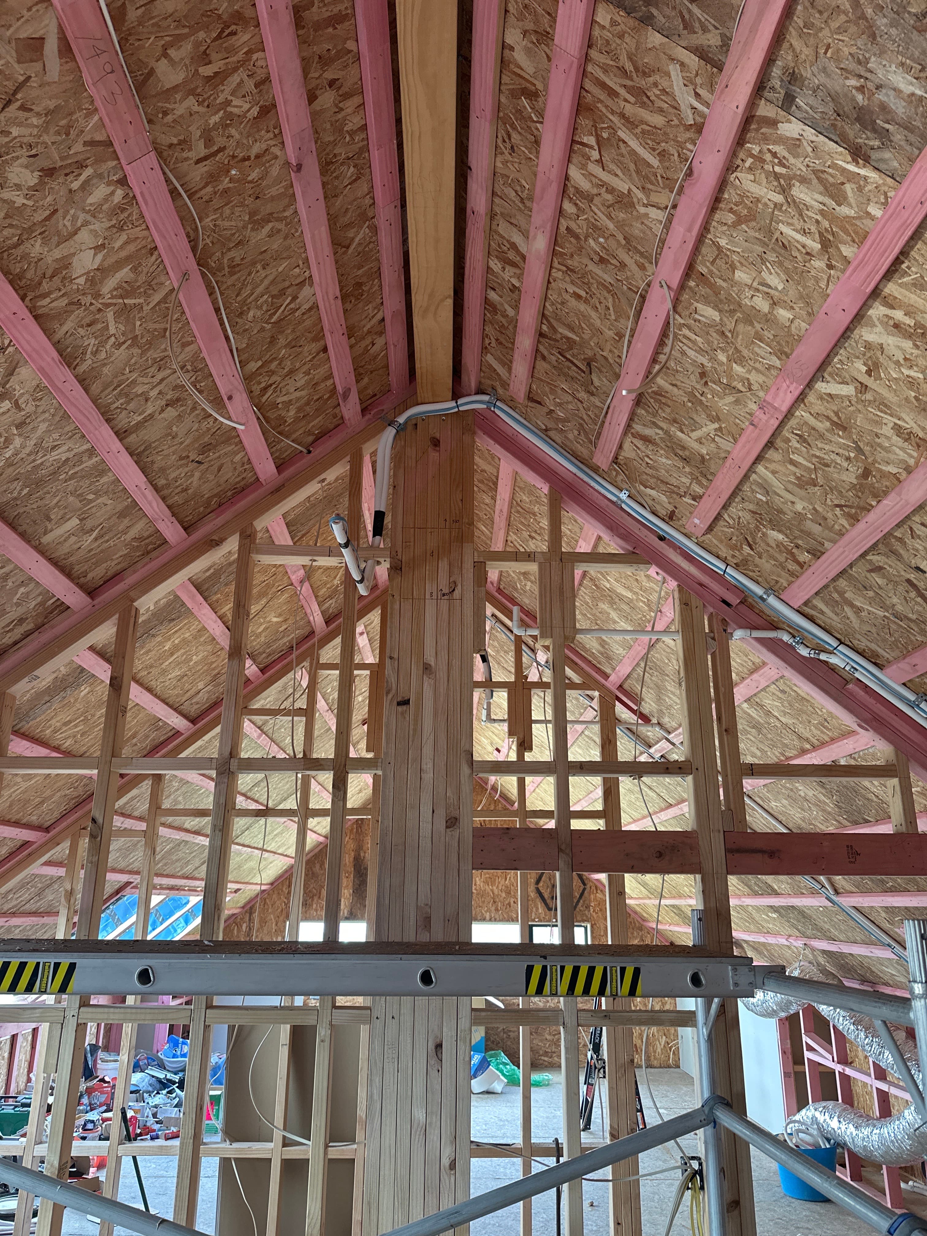 Panasonic multi-split heat pump refrigerant pipework routed through exposed timber roof framing during a new home construction in Cambridge, Waikato.